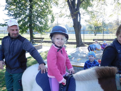 Koník Kaštánek s dětmi ze třídy Sluníčka  na školní zahradě